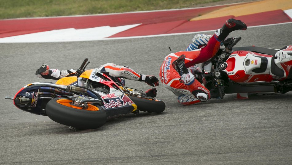 Dani Pedrosa, of Spain, left, crashes with Andrea Dovizioso, of Italy, in Turn 1 at the MotoGP Red Bull Grand Prix of the Americas at the Circuit of the Americas in Austin, Texas